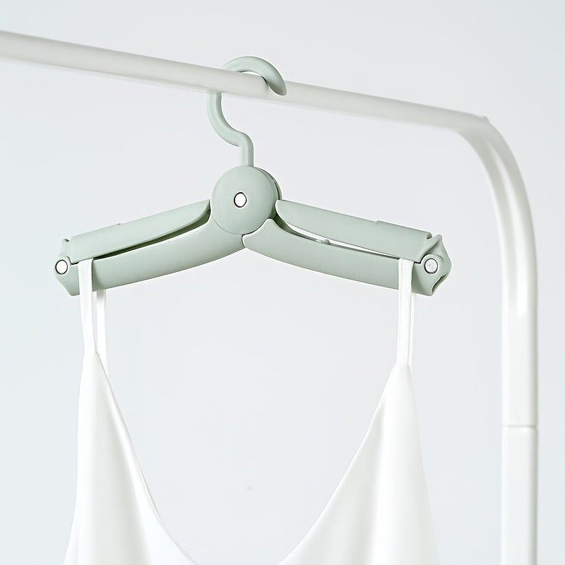 Folding hanger holding a top on a rail